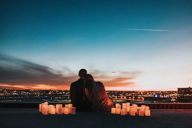 A couple enjoying a candlelit evening over a city view